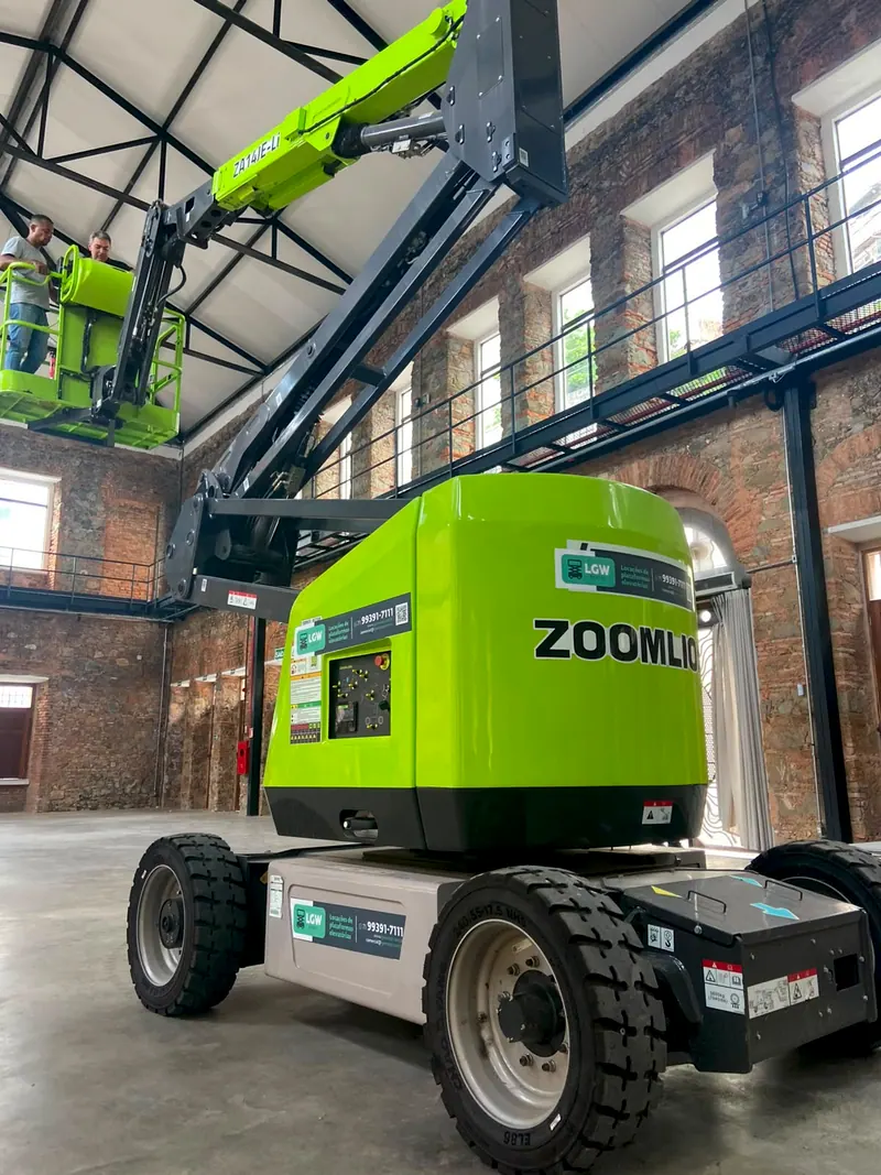 Plataforma articulada verde Zoomlion num galpão de tijolos